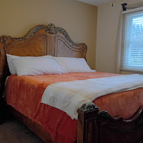 Second bedroom with an ornate wooden headboard and warm bedding